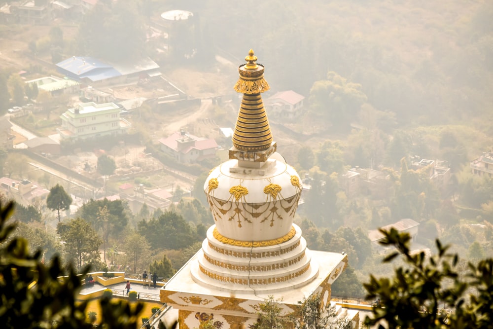 gold and white temple on top of mountain