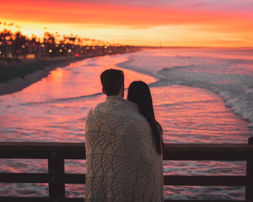 couple standing on beach during sunset