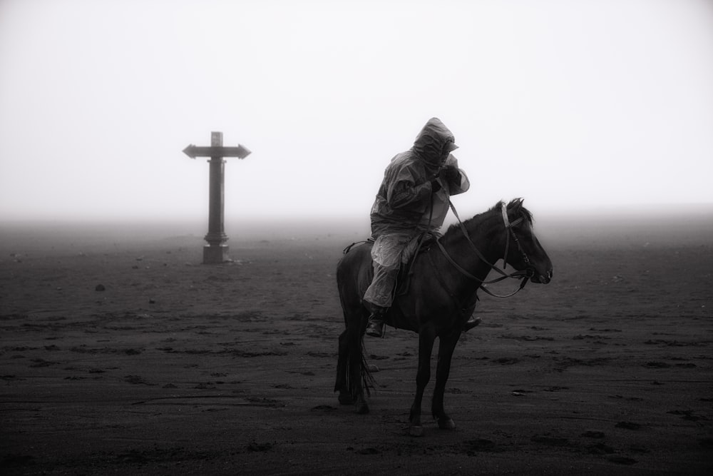 grayscale photo of woman riding on horse on beach