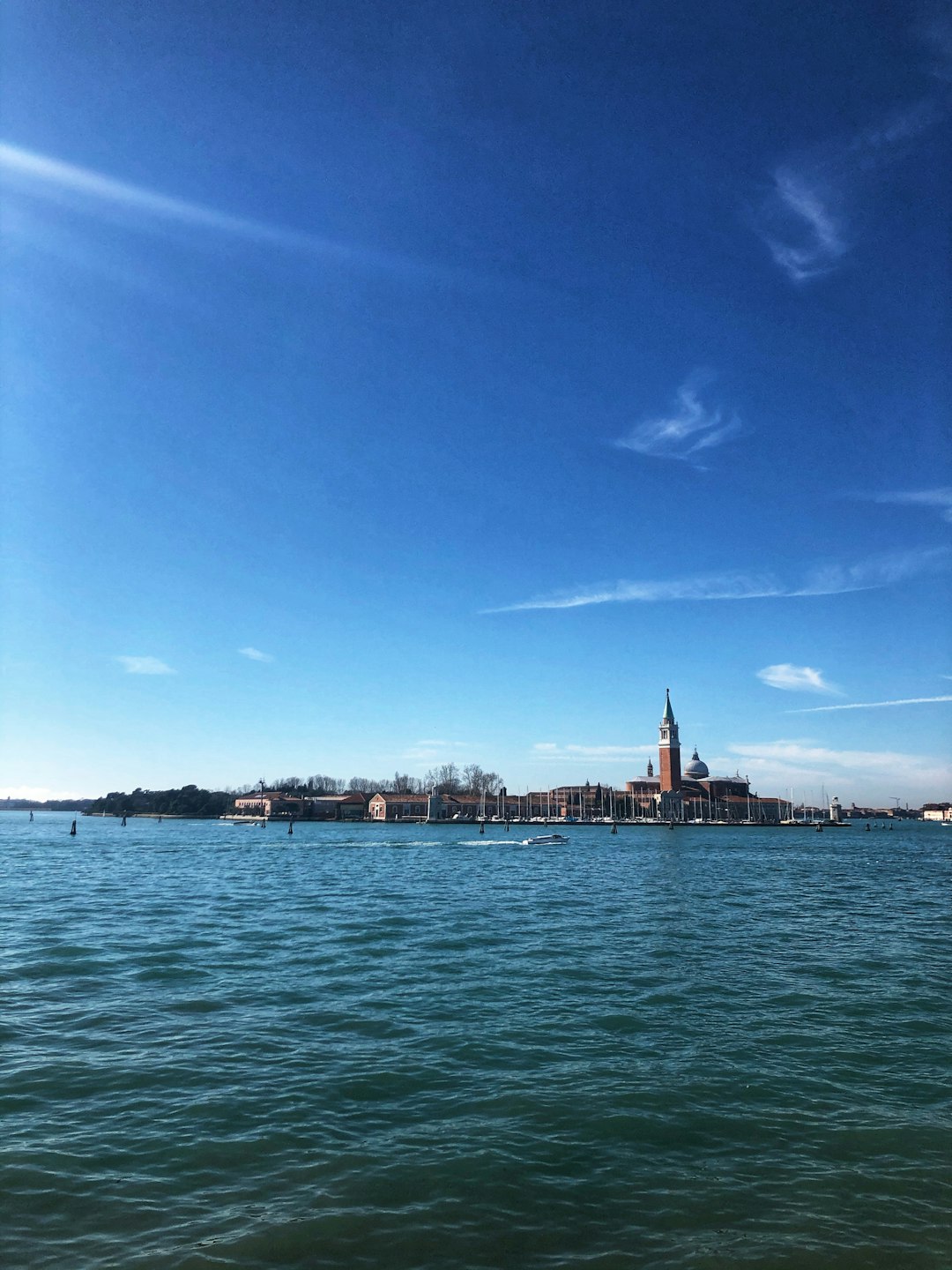 body of water near city buildings under blue sky during daytime