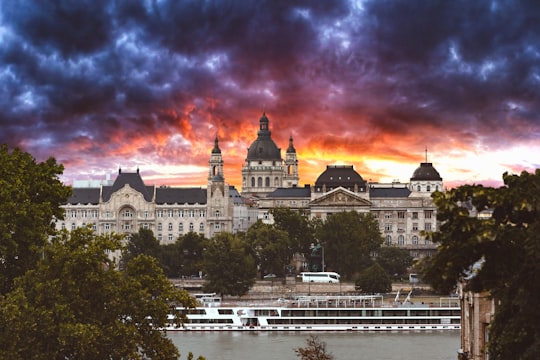 white concrete building near green trees under cloudy sky during daytime in Széchenyi Chain Bridge Hungary