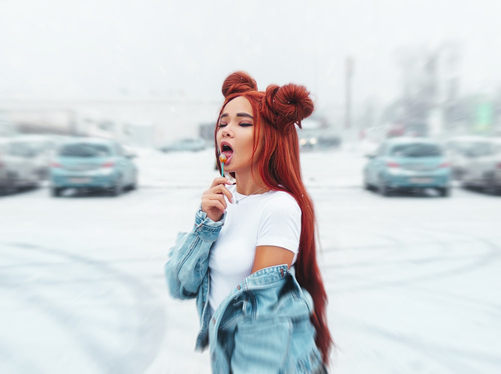 woman in teal off shoulder dress holding white and blue lollipop