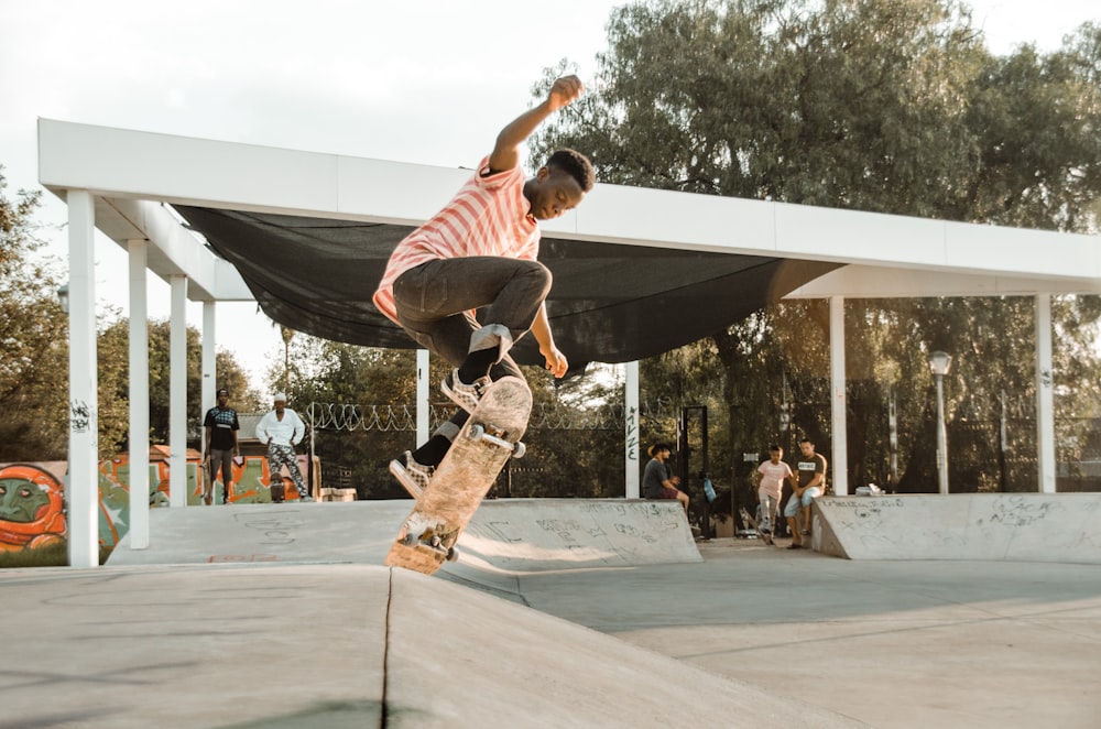 man in brown shirt and brown pants jumping on gray concrete floor during daytime