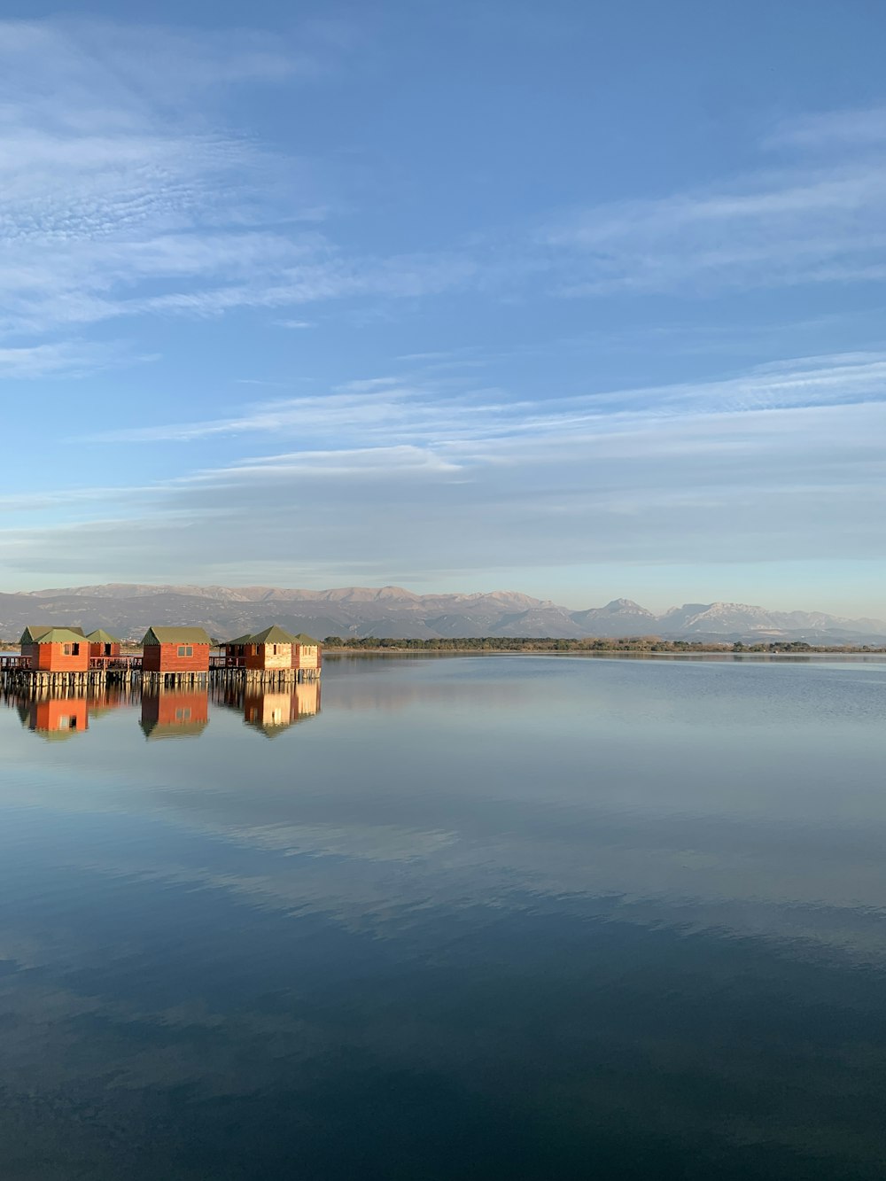 brown concrete building on body of water under blue sky during daytime