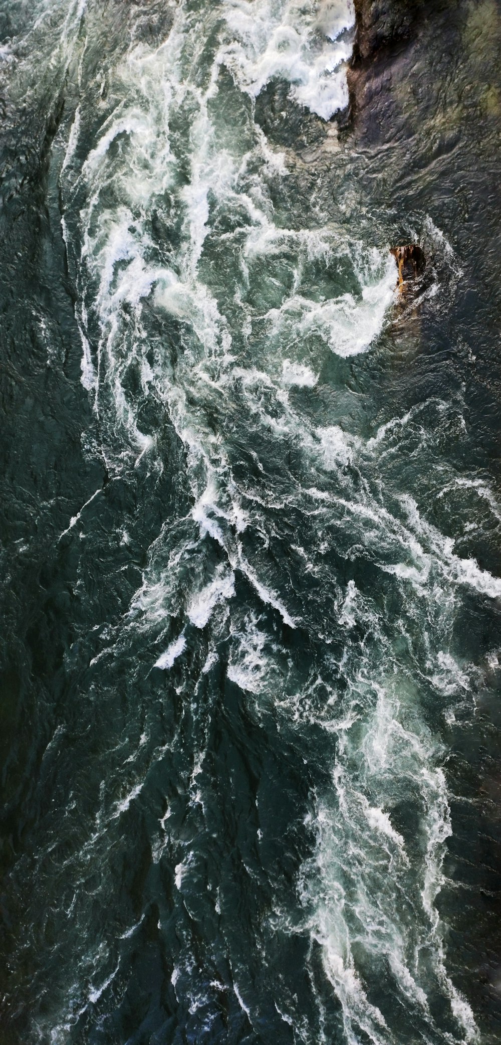 water waves hitting rocks during daytime