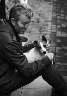 Photo of a friendly animal control officer gently handling a rescued dog outside the font llc office.