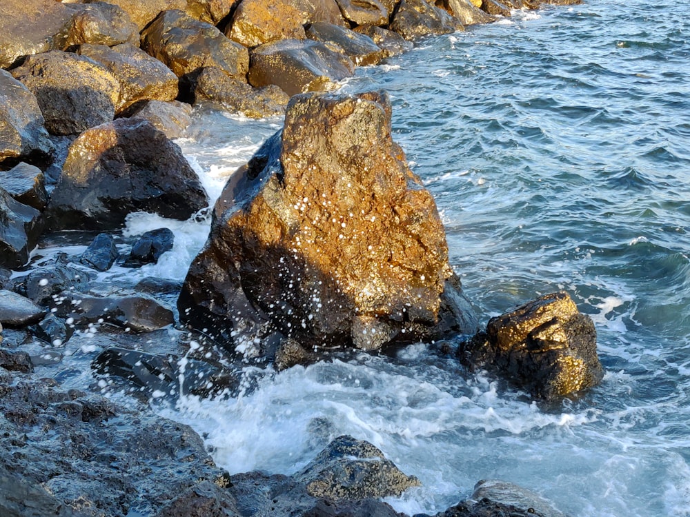 brown rock formation beside body of water during daytime