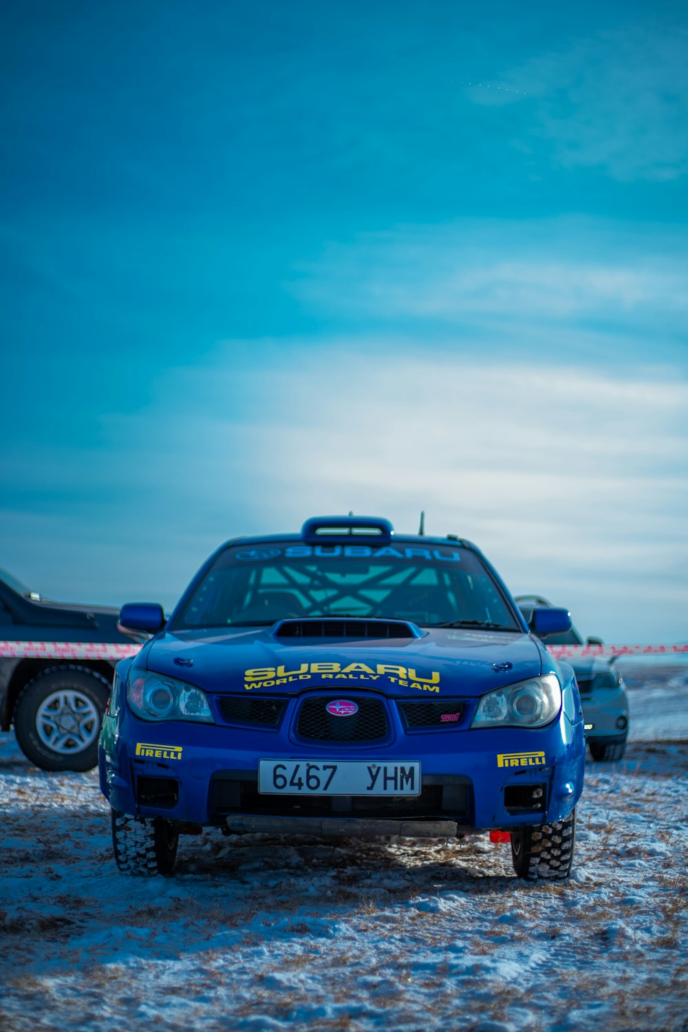 blue bmw m 3 on gray sand under white clouds during daytime