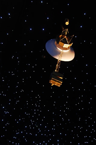 Close-up of a satellite dish pointing towards a glowing planet in deep space.