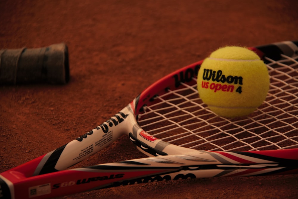 green tennis ball beside tennis racket