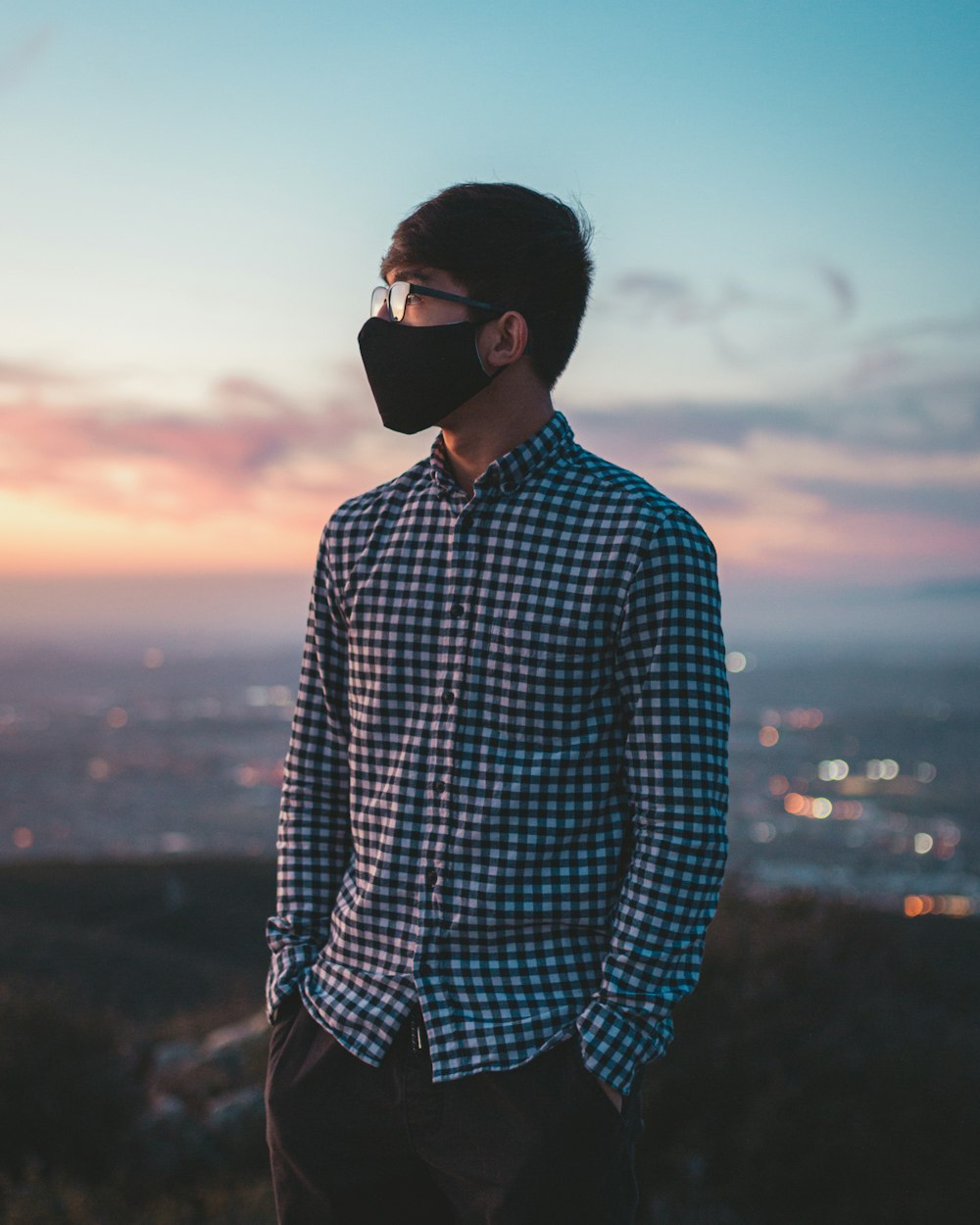 man in blue and white checkered dress shirt wearing black sunglasses during sunset