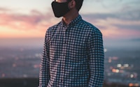 man in blue and white checkered dress shirt wearing black sunglasses during sunset