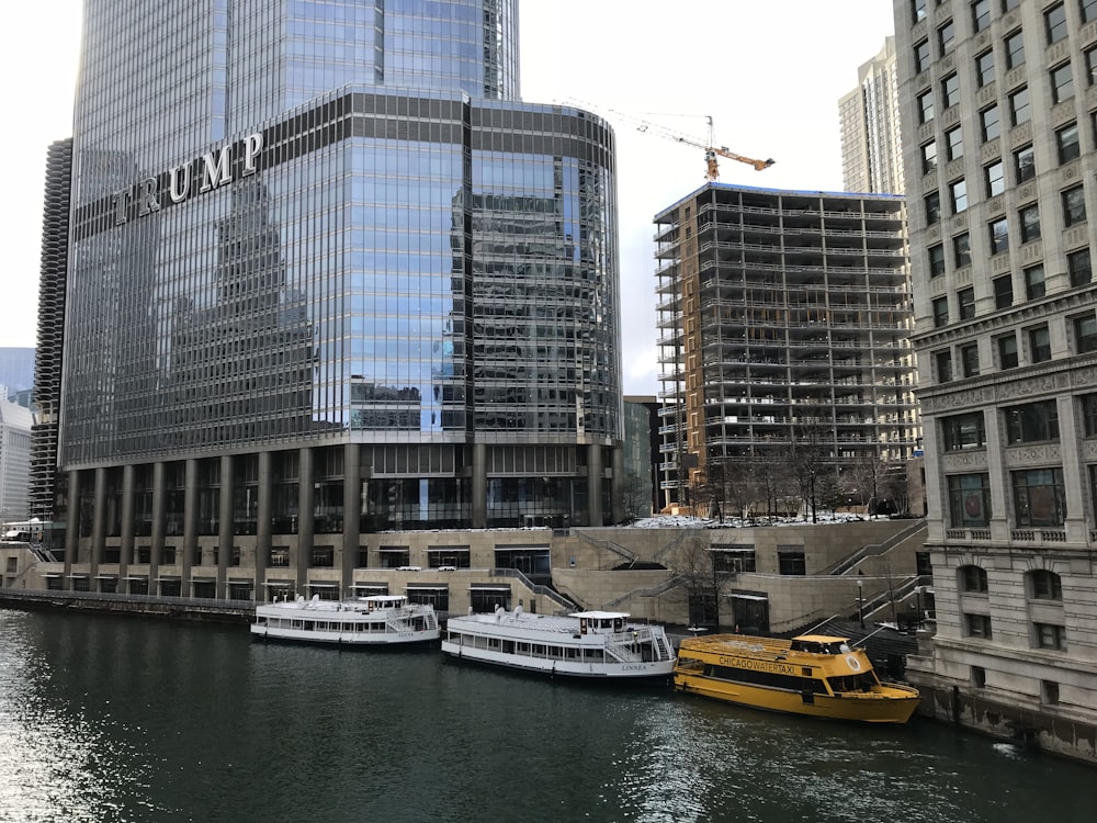 yellow and white boat on body of water near high rise buildings during daytime