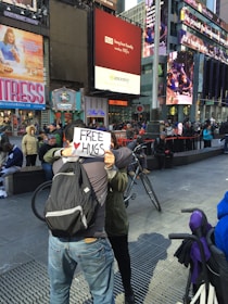 Volunteers handing out flyers and smiling warmly on a busy city street.