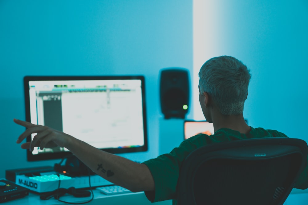 man in red long sleeve shirt sitting in front of computer