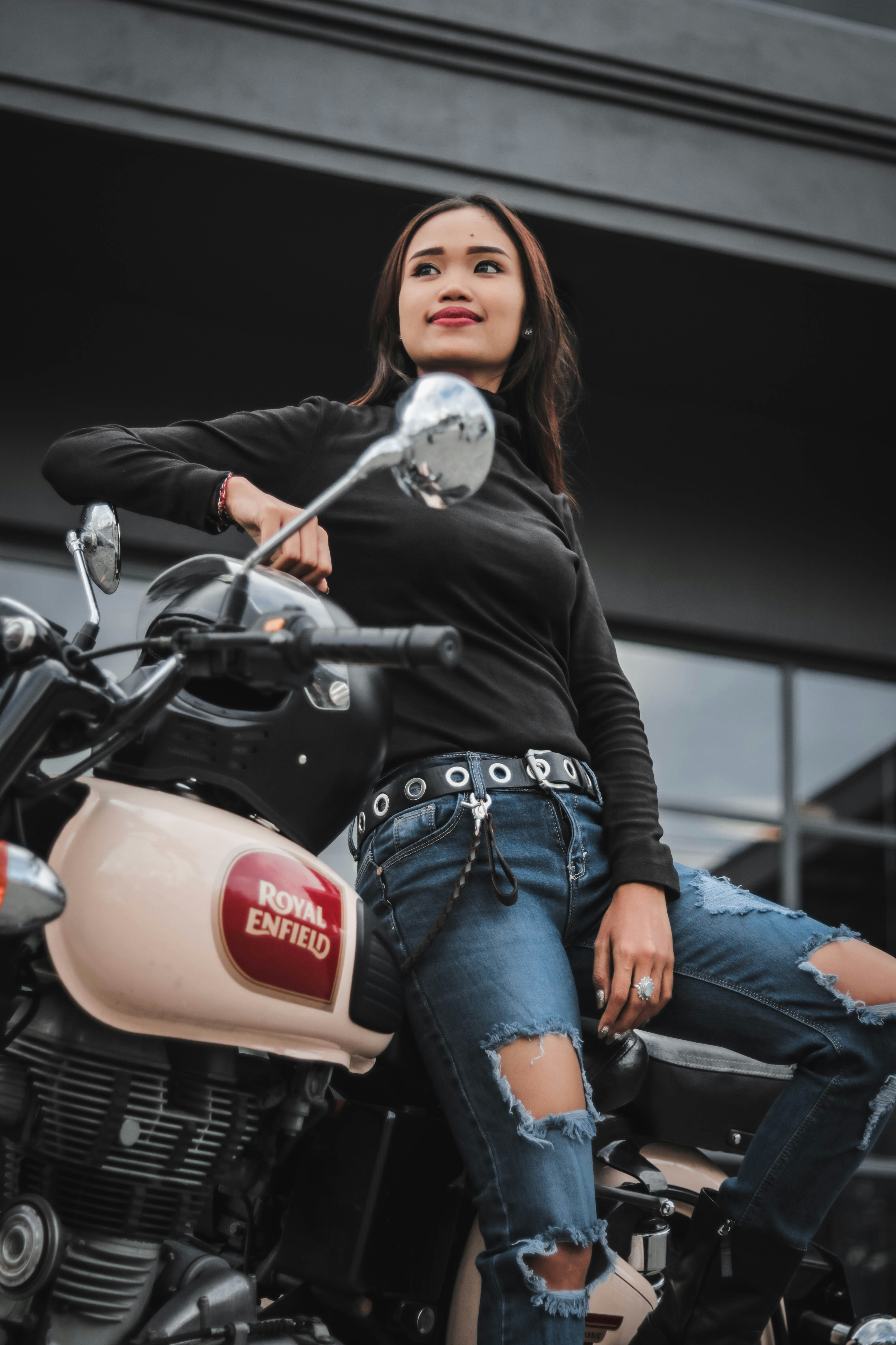 A woman sitting on top of a motorcycle