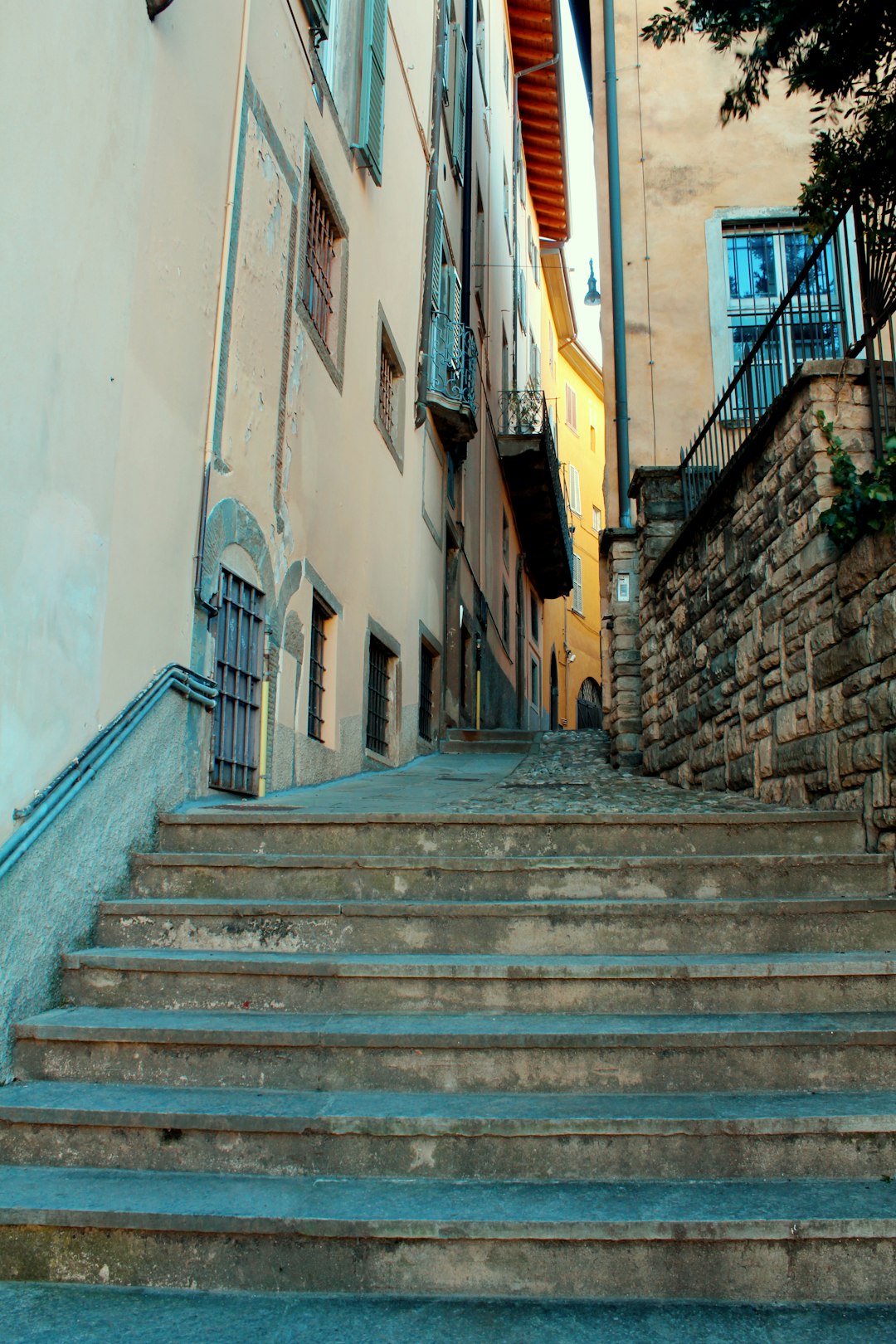 gray concrete stairs between white and yellow concrete buildings during daytime