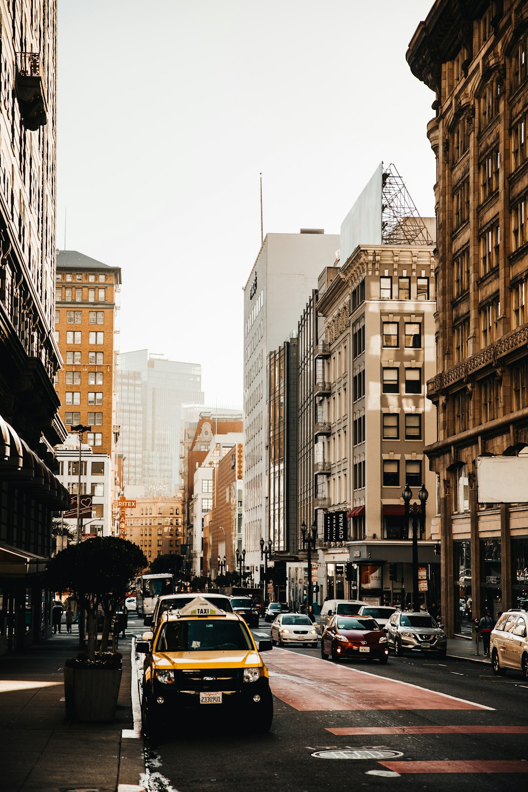 cars on road between high rise buildings during daytime