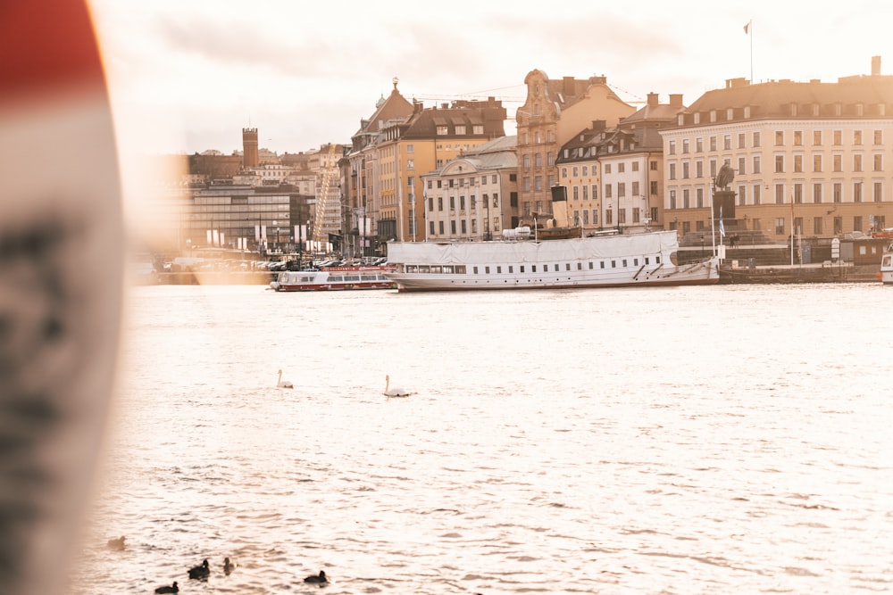 people riding on boat on sea near buildings during daytime