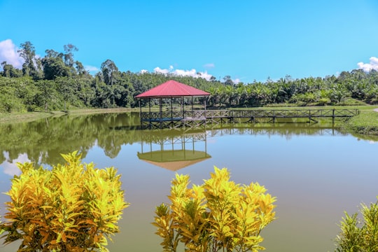 red and white house near lake surrounded by green trees under blue sky during daytime in Bakun Malaysia