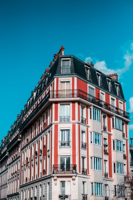 red and white concrete building under blue sky during daytime in Square Louise Michel France