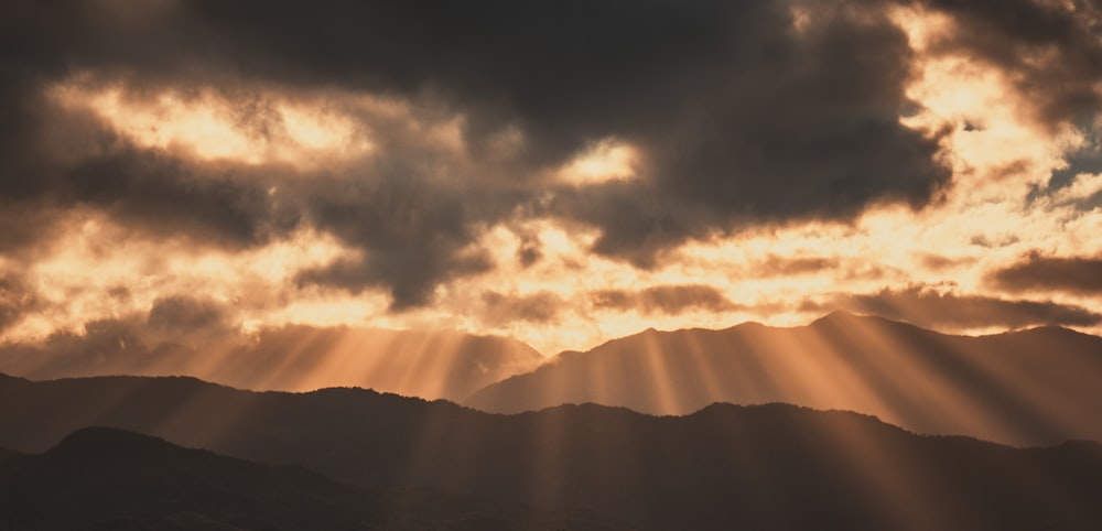 silhouette of mountains under cloudy sky during daytime