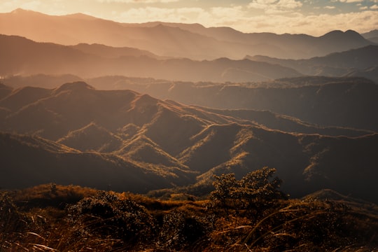 brown mountains under white clouds during daytime in Mount Balagbag Philippines