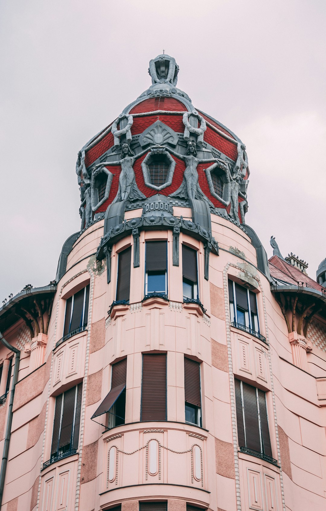 brown concrete building with red and black roof