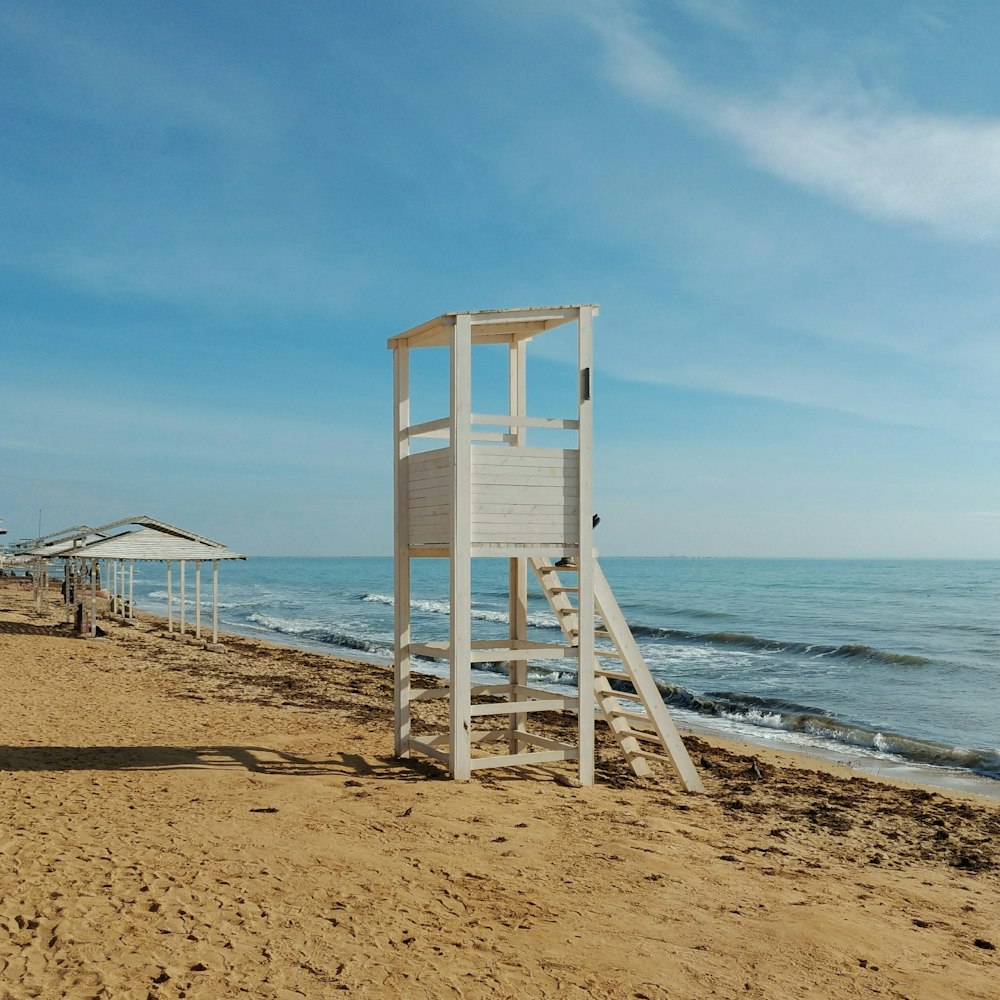 brown wooden lifeguard tower on beach shore during daytime