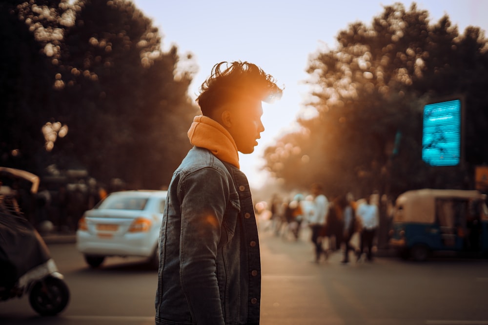 woman in black denim jacket standing on road during daytime