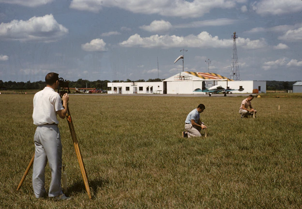 Wide shot of a cadastral mapping project with engineers discussing plans outdoors