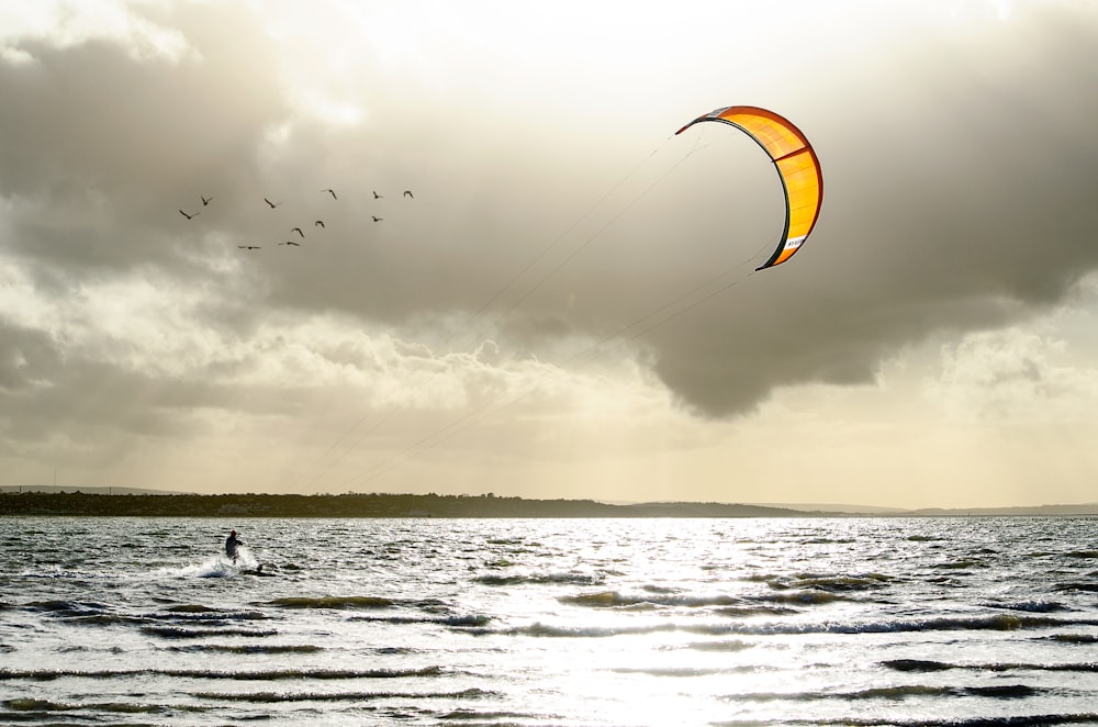 gente surfeando en el mar bajo el cielo nublado durante el día