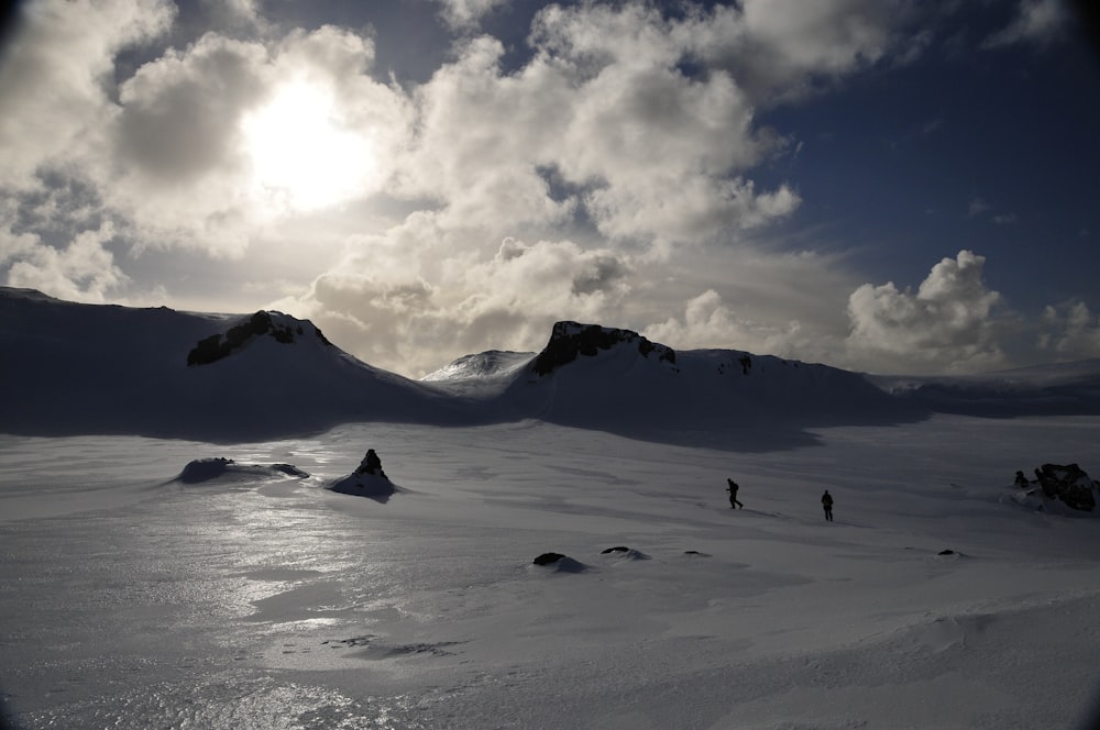 montagne enneigée sous un ciel nuageux pendant la journée