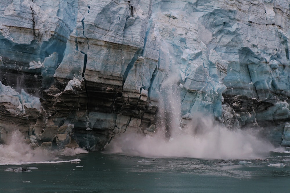 Spruzzi d'acqua sulla formazione rocciosa marrone durante il giorno