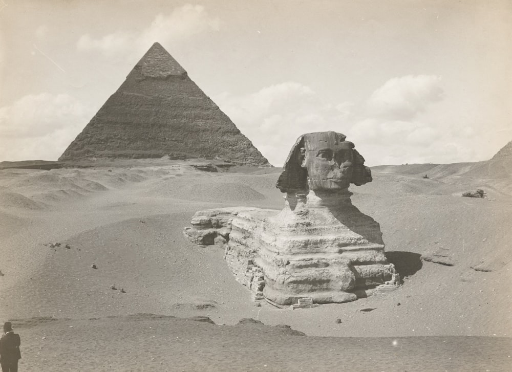 grayscale photo of pyramid on sand