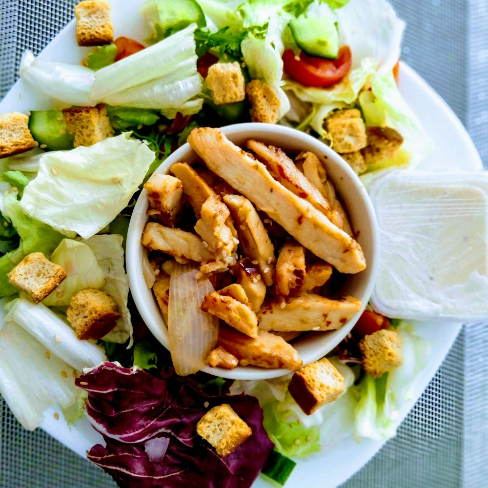 sliced meat and vegetable salad on white ceramic plate