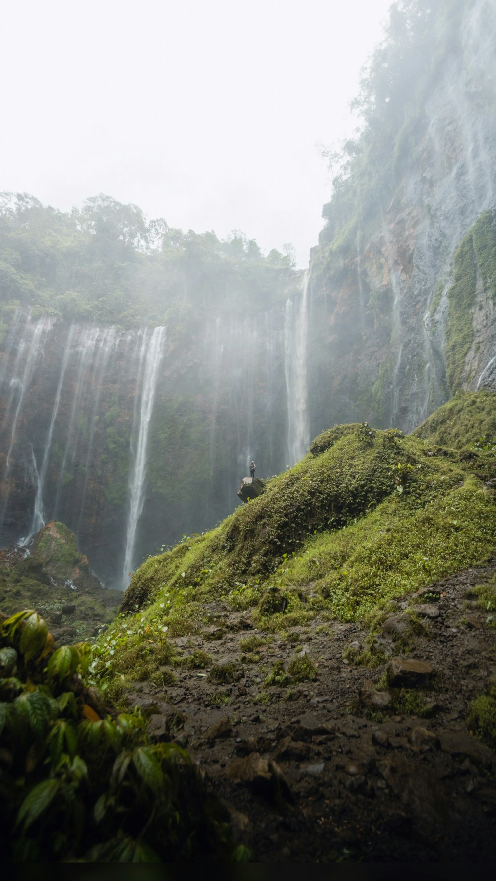 waterfalls in the middle of green grass covered mountain