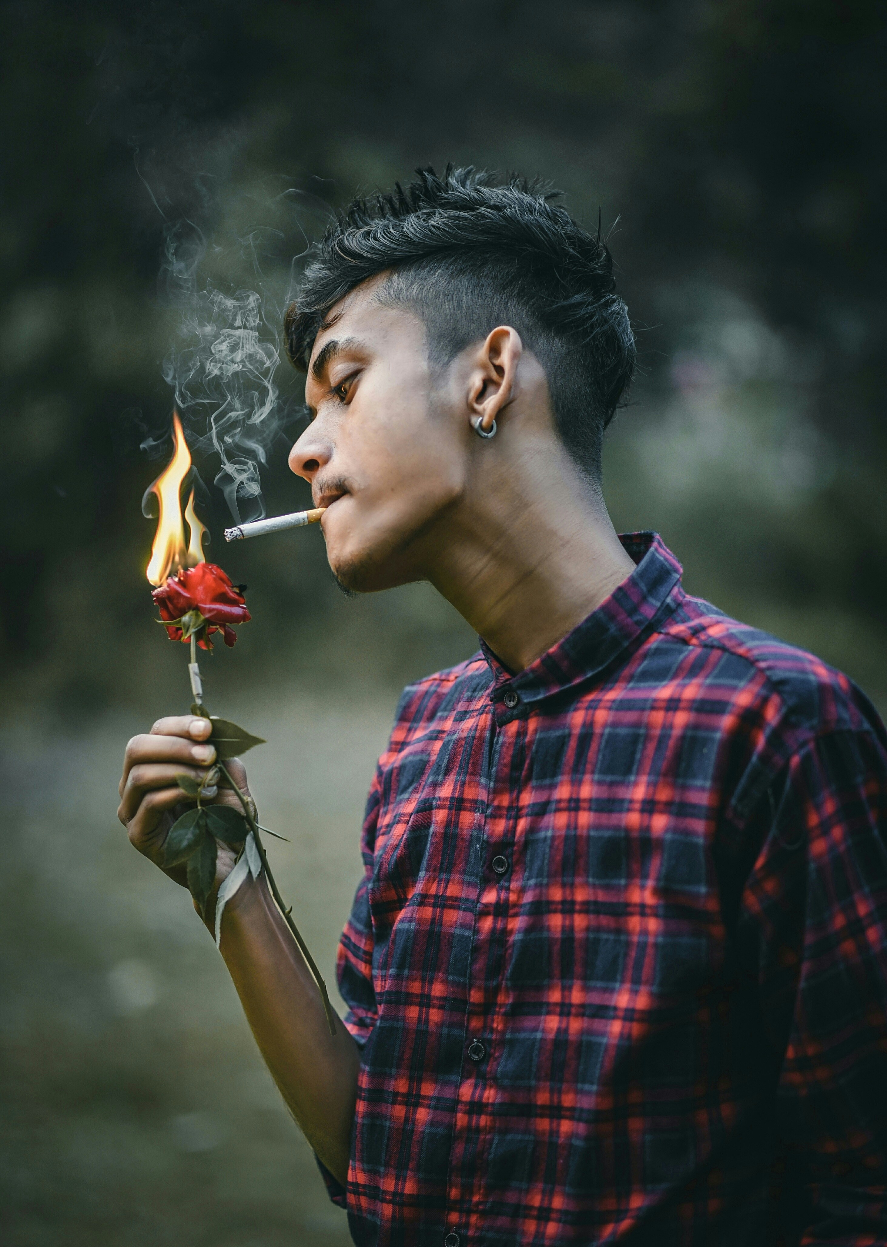 man in red and black plaid button up shirt smoking