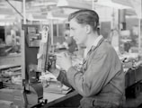 Technician operating a CNC machine in a bright, organized workshop.