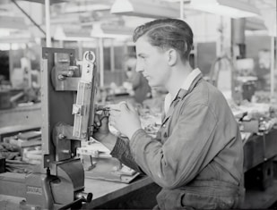 Close-up of skilled workers operating rubber boot production machinery in a busy factory.