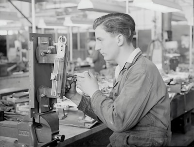 A young professional happily working in a modern German workshop, showcasing practical vocational training.