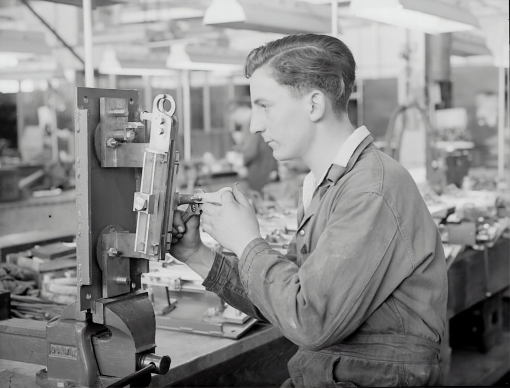 homme en veste grise tenant une machine