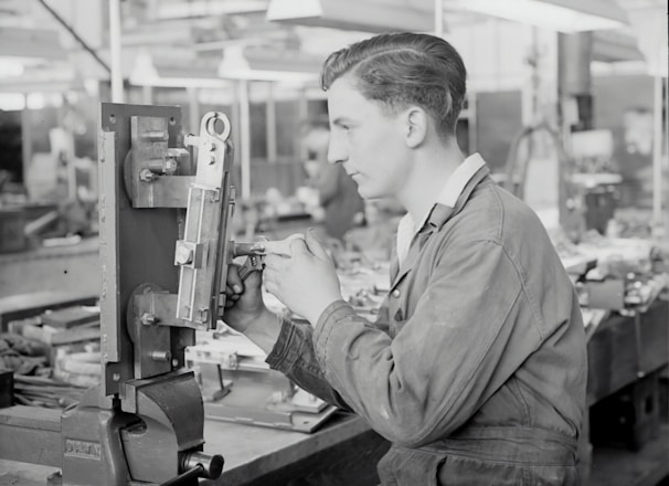 man in gray jacket holding a machine