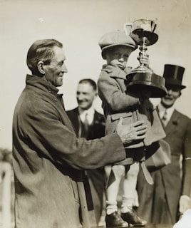 A young child holding a trophy with family, preserving family history through storytelling