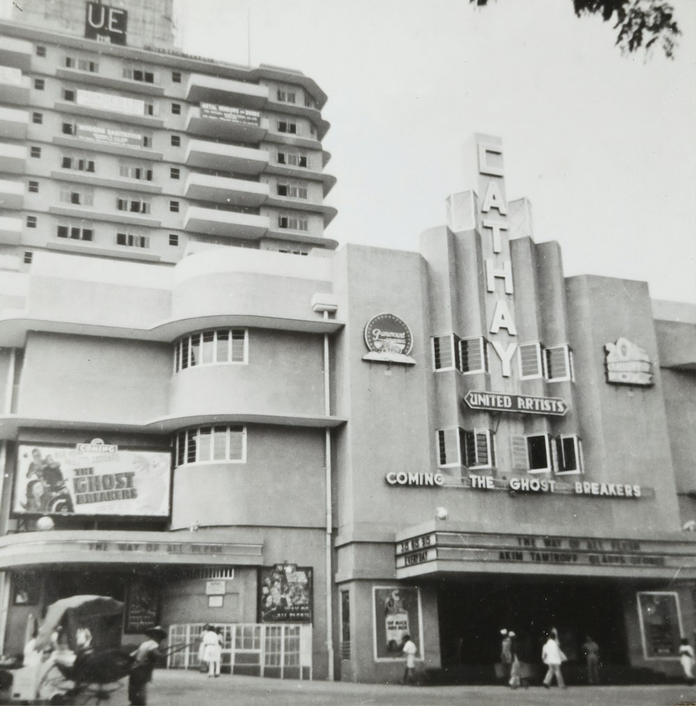 grayscale photo of people in front of building