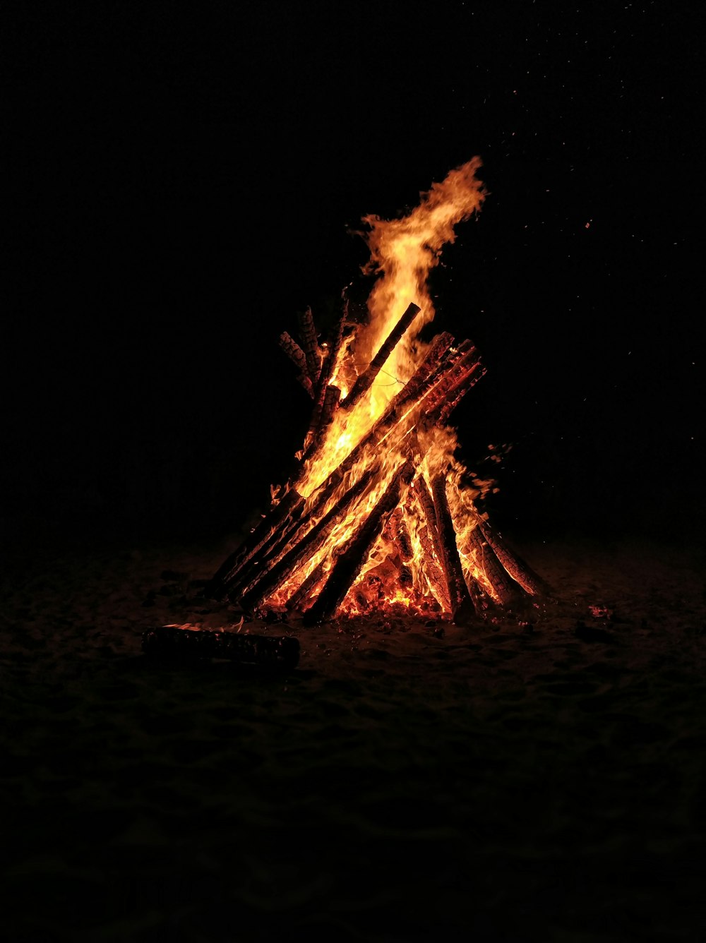 夜の茶色い砂浜の焚き火