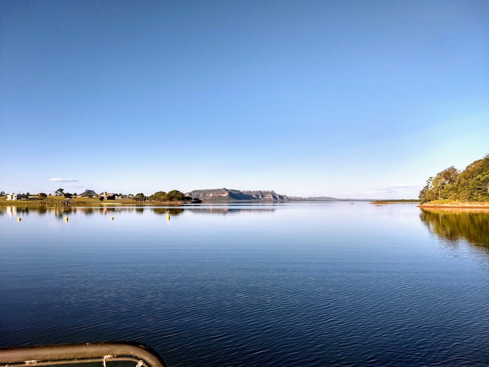 white boat on water under blue sky during daytime