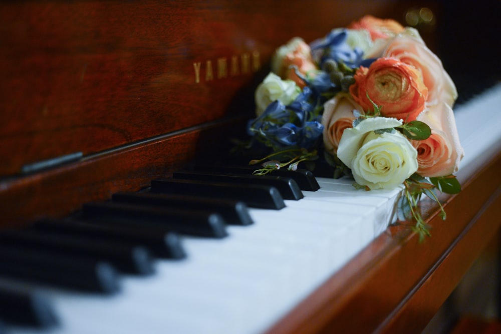 white and pink rose on piano