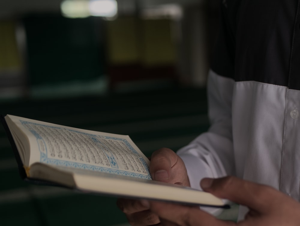 person in white long sleeve shirt reading book