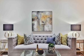 A modern living room featuring a bold, geometric tufted rug from Color Invaders.